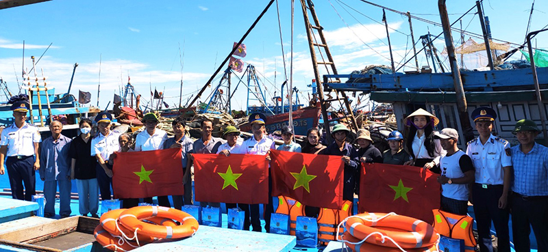 Đại diện Bộ Tư lệnh Vùng Cảnh sát biển 1 và cấp ủy, chính quyền địa phương tặng cờ Tổ quốc và pháo cứu sinh cho ngư dân.