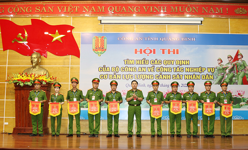 Đại tá Nguyễn Tiến Hoàng Anh, Phó Giám đốc Công an tỉnh trao cờ lưu niệm cho các đội tham gia hội thi.