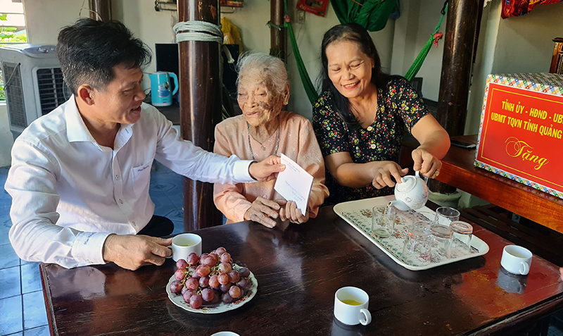 Đồng chí Trưởng ban Dân vận Tỉnh ủy  Lê Văn Bảo và các thành viên đoàn công tác tặng quà mẹ VNAH Nguyễn Thị Can.