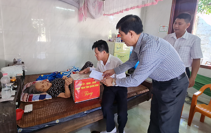 Đồng chí Trưởng ban Dân vận Tỉnh ủy  Lê Văn Bảo và các thành viên đoàn công tác tặng quà mẹ VNAH Nguyễn Thị Tôi.
