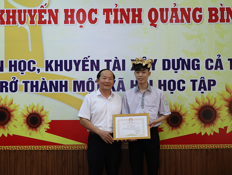  Chủ tịch Hội Khuyến học tỉnh Trần Xuân Vinh trao giấy khen và quà chúc mừng em Trần Lê Bảo Lâm.