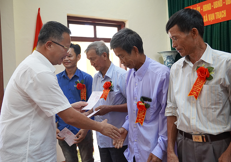 Đồng chí Phó Chủ tịch UBND huyện Bố Trạch Nguyễn Hữu Hồng trao sổ tiết kiệm cho các gia đình người có công trên địa bàn xã Vạn Trạch.