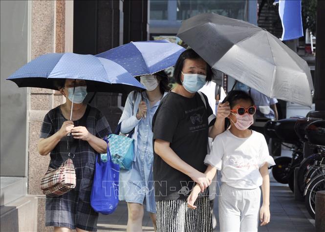 Người dân di chuyển dưới trời nắng nóng tại Thượng Hải, Trung Quốc ngày 13/7/2022. Ảnh: Kyodo/TTXVN