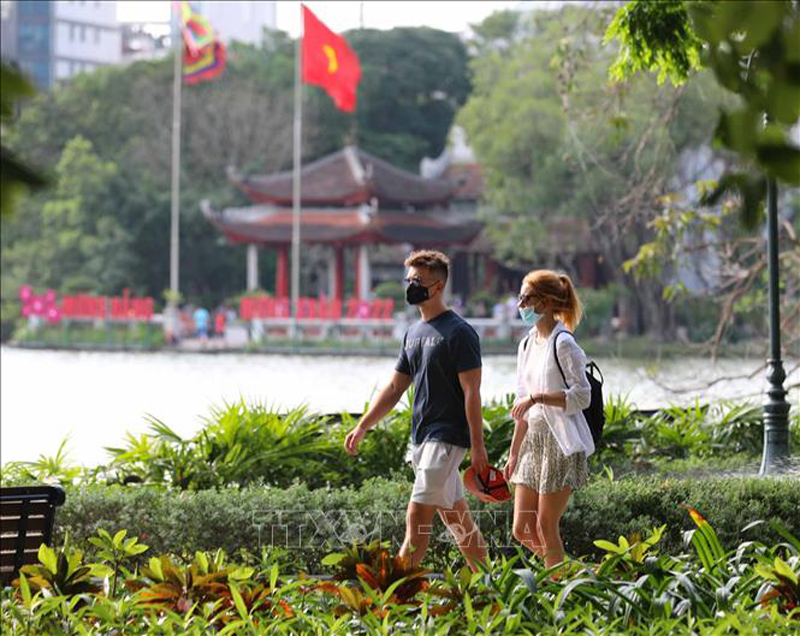 Du khách quốc tế đi dạo, ngắm cảnh Hồ Gươm. Ảnh: Thanh Tùng/TTXVN