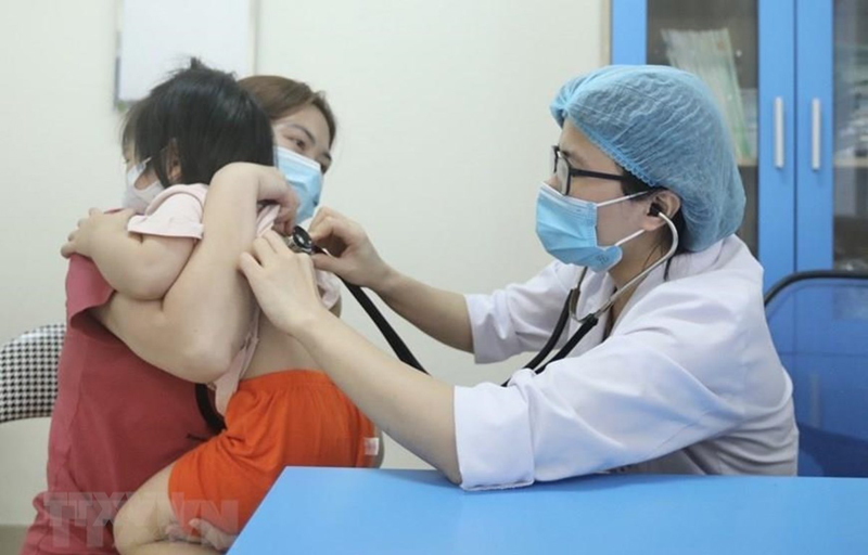 Bác sỹ Bệnh viện Bệnh nhiệt đới Trung ương khám cho bệnh nhi xuất hiện triệu chứng cúm A. (Ảnh: Minh Quyết/TTXVN)
