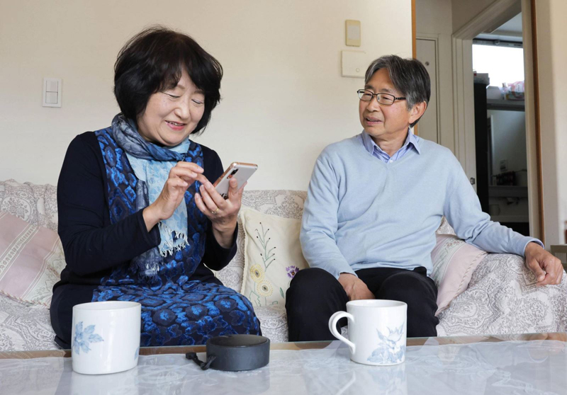 Bà Michiko Sakai (trái) trò chuyện với chồng bằng dịch vụ tái tạo giọng nói của CoeFont. Ảnh: KYODO