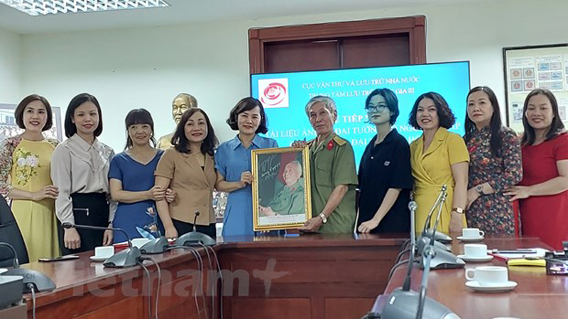 Đại tá Trần Hồng trao tặng hiện vật ảnh cho Trung tâm Lưu trữ Quốc gia III. (Ảnh: Minh Thu/Vietnam+)