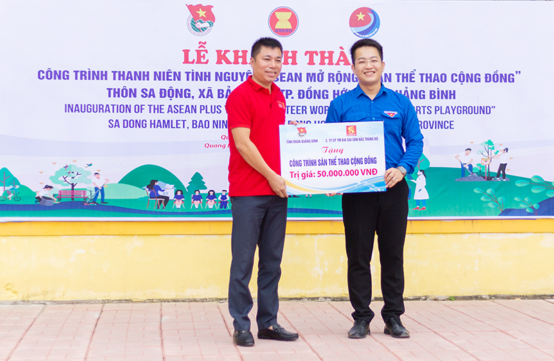  Đại diện lãnh đạo Tỉnh đoàn nhận bảng tượng trưng tiền hỗ trợ của nhà tài trợ xây dựng sân thể thao cộng đồng ở xã Bảo Ninh (Đồng Hới).