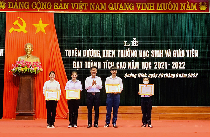 Đồng chí Bí thư Huyện uỷ Quảng Ninh Trần Quốc Tuấn trao thưởng cho học sinh có thành tích cao trong năm học 2021-2022.