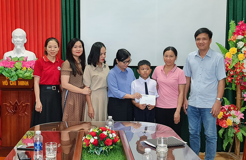 Đại diện lãnh đạo Báo Quảng Bình, Hội Chữ thập đỏ xã Xuân Ninh và CLB Giọt hồng Quảng Bình trao tiền hỗ trợ cho em Đặng Minh An.