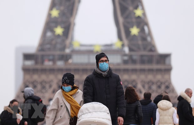 Người dân đeo khẩu trang phòng COVID-19 khi đi trên đường phố Paris, Pháp ngày 29/12/2021. (Ảnh: THX/TTXVN)