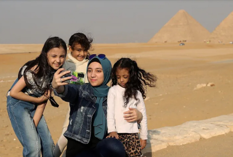 Du khách chụp ảnh bên quần thể kim tự tháp Giza ở Ai Cập. (Nguồn: Business Insider)