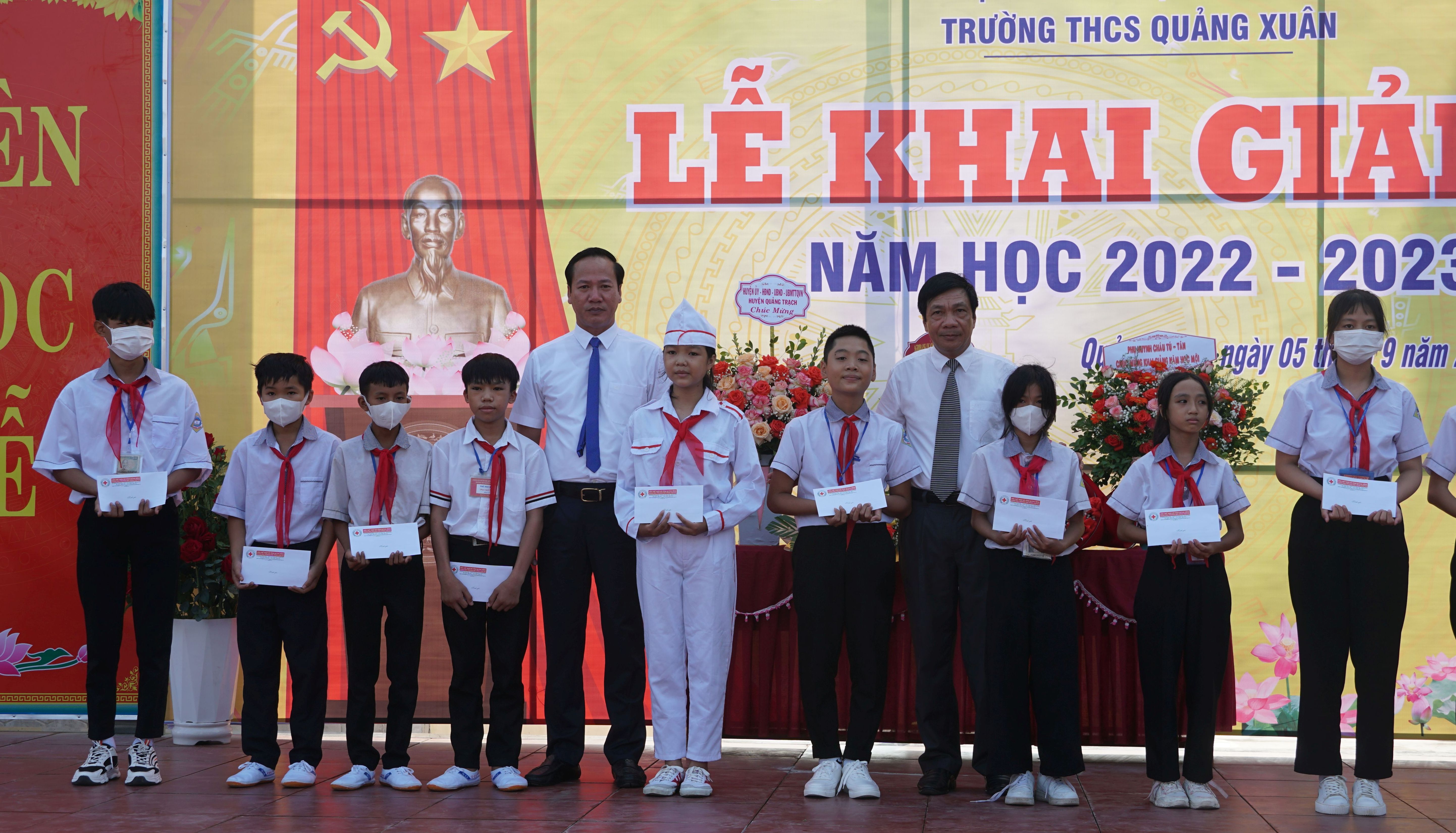 Đồng chí Phó Chủ tịch Thường trực HĐND tỉnh Nguyễn Công Huấn và đồng chí Bí thư Huyện ủy Quảng Trạch Nguyễn Xuân Đạt trao học bổng cho các em học sinh ở Trường THCS Quảng Xuân.