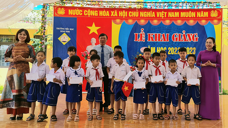 Đồng chí Chủ tịch Uỷ ban MTTQ Việt Nam tỉnh tặng quà cho học sinh Trường tiểu học Hàm Ninh.