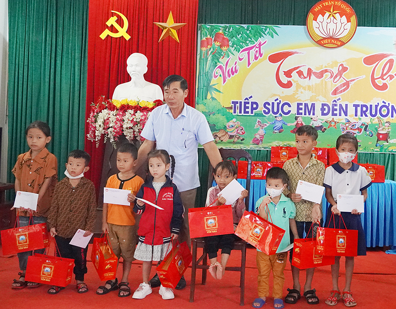 Đại diện lãnh đạo Ủy ban MTTQ Việt Nam huyện Bố Trạch trao quà và học bổng cho các em học sinh.