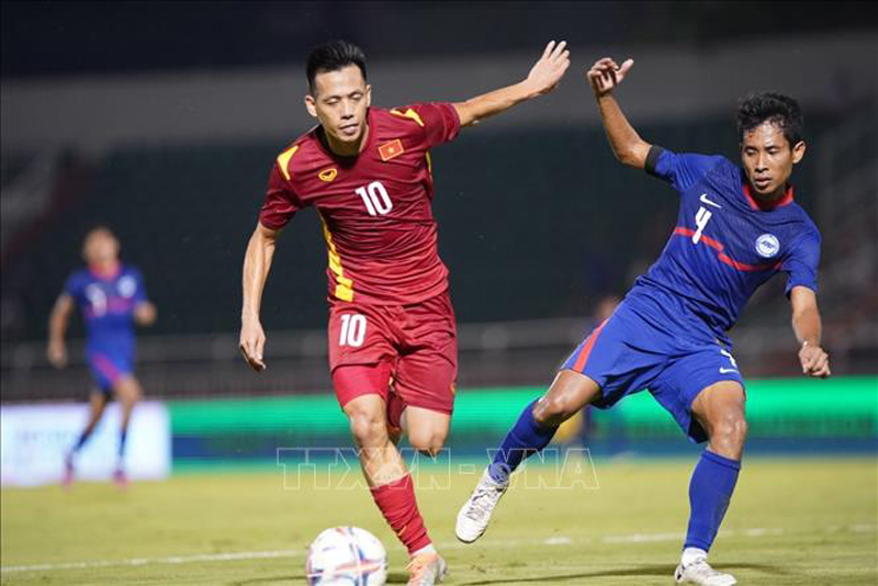 Pha tranh bóng giữa cầu thủ đội tuyển Việt Nam (áo đỏ) với đội tuyển Singaopre (áo xanh). Ảnh: Thanh Vũ/TTXVN