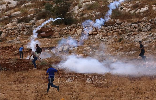 Người biểu tình Palestine ném hơi cay về phía binh lính Israel tại Nablus, Khu Bờ Tây, ngày 23/9/2022. Ảnh: THX/TTXVN