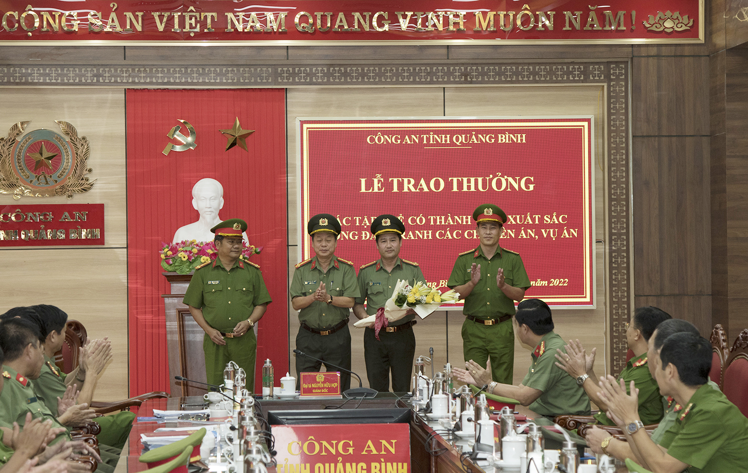 Đại tá Nguyễn Hữu Hợp, Giám đốc Công an tỉnh tặng hoa chúc mừng các đơn vị tham gia phá án vụ bắt đánh bạc tại TX. Ba Đồn.