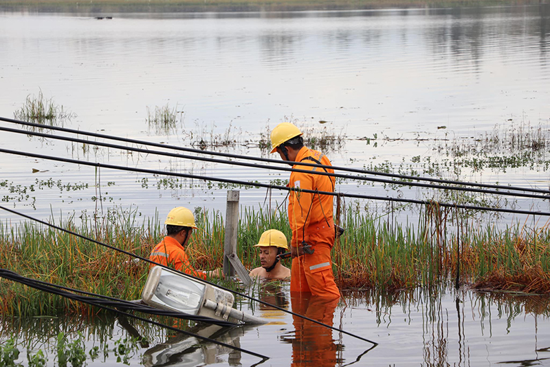 Nhiều công nhân PC Quảng Bình phải ngâm mình dưới nước nhiều giờ đồng hồ để khắc phục sự cố lưới điện tại Quảng Nam.