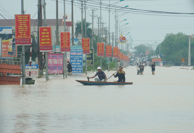 Tuyến đường từ ngả tư Cam Liên đi vào trung tâm huyện Lệ Thủy bị ngập khá sâu, nhiều người dân dùng thuyền để đi lại.