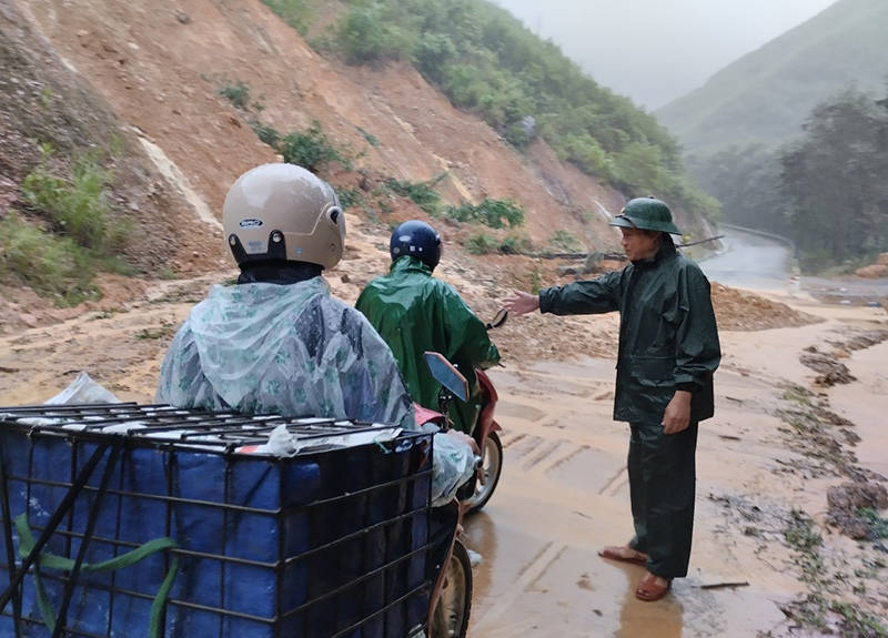 Bộ đội Biên phòng hướng dẫn, phân luồng người dân lưu thông qua Quốc lộ 9C, xã Kim Thủy (Lệ Thủy).