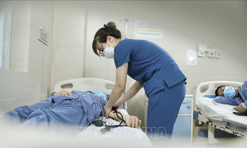 Điều dưỡng chăm sóc bệnh nhân đang điều trị cúm A tại bệnh viện Thanh Nhàn. Ảnh: Minh Quyết/TTXVN