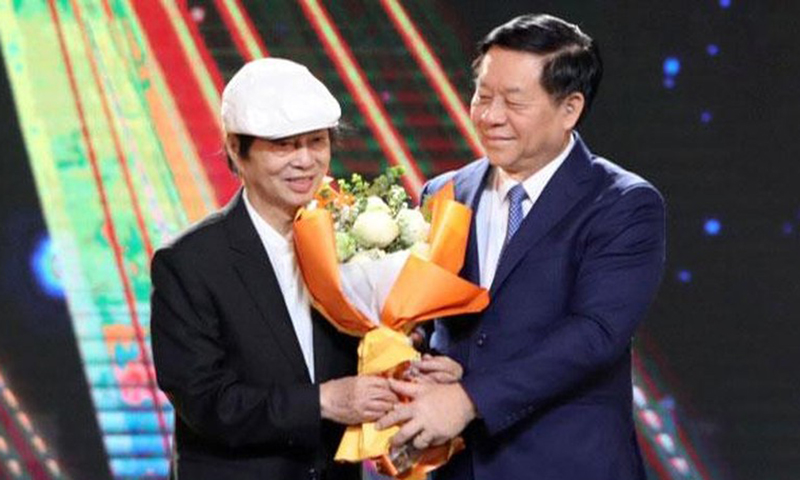 Đồng chí Nguyễn Trọng Nghĩa tặng hoa cho đạo diễn, NSND Đặng Nhật Minh.