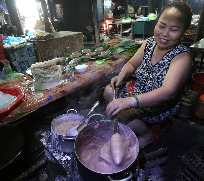 Thao tác quấy nồi bánh đúc ngay tại lò của một nghệ nhân tại chợ Ba Đồn.