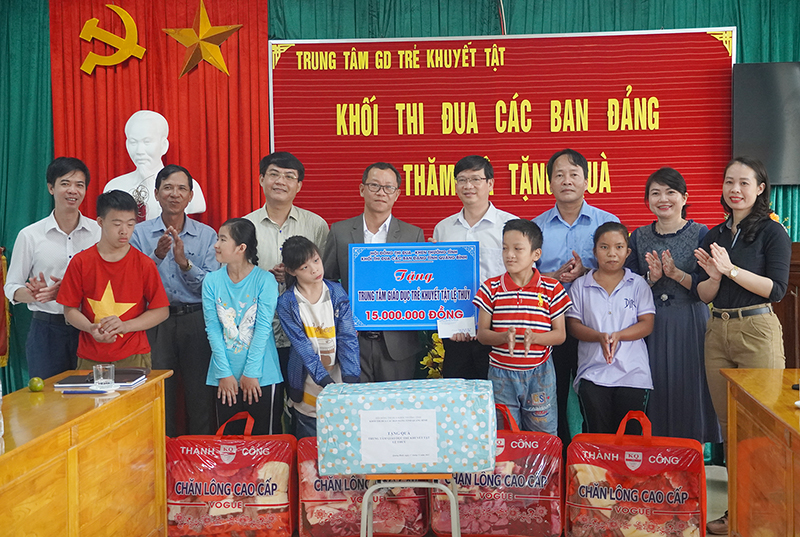 Các đồng chí lãnh đạo trong Khối thi đua các ban Đảng trao tiền và quà hỗ trợ cho Trung tâm giáo dục trẻ khuyết tật Lệ Thủy. 