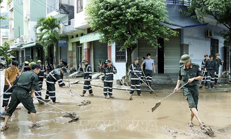 Lực lượng Cảnh sát cơ động tham gia dọn dẹp, vệ sinh lại nhiều đoạn đường tại Phường Ghềnh Ráng,TP Quy Nhơn, Bình Định. Ảnh: TTXVN phát