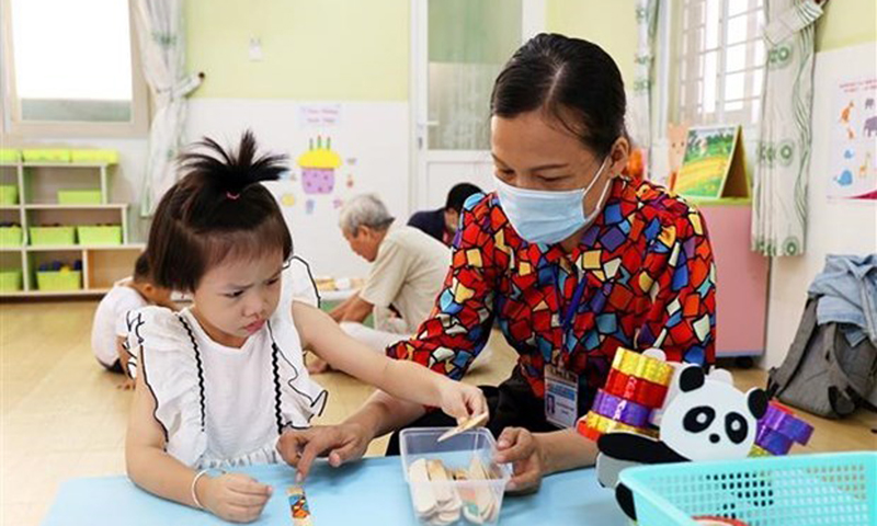 Giáo viên trường Mầm non Sơn Ca 14, quận Phú Nhuận, Thành phố Hồ Chí Minh dạy trẻ nhận biết đồ vật. (Ảnh: Hồng Đạt/TTXVN)