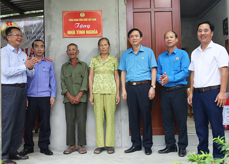Lãnh đạo LĐLĐ tỉnh và các đại biểu gắn biển trao nhà tình nghĩa cho gia đình ông Nguyễn Văn Bang.