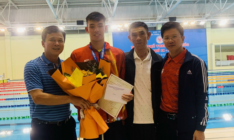 Đại diện lãnh đạo Sở Văn hoá và Thể thao tặng hoa chúc mừng VĐV Nguyễn Huy Hoàng sau khi giành HCV ở nội dung thi đấu.