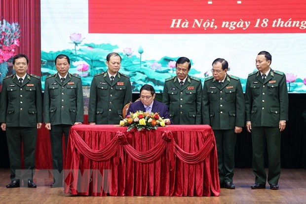 Thủ tướng Phạm Minh Chính viết sổ lưu niệm khi đến thăm và làm việc với Bộ Tư lệnh Bộ đội Biên phòng. (Ảnh: Dương Giang/TTXVN)