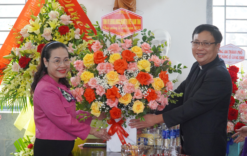 Đồng chí Chủ tịch Ủy ban MTTQVN tỉnh Phạm Thị Hân tặng hoa chúc mừng linh mục Trần Văn Thành.