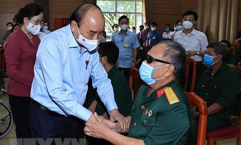 Chủ tịch nước Nguyễn Xuân Phúc đến thăm, tặng quà cho thương binh, bệnh binh tại Trung tâm nuôi dưỡng thương bệnh binh nặng và điều dưỡng người có công tỉnh Hà Nam. (Ảnh: Thống Nhất/TTXVN)