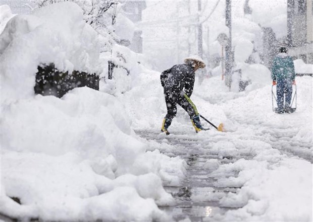 Người dân dọn tuyết trên đường phố tại Nagaoka, tỉnh Niigata (Nhật Bản), ngày 19/12/2022. (Ảnh: Kyodo/TTXVN)