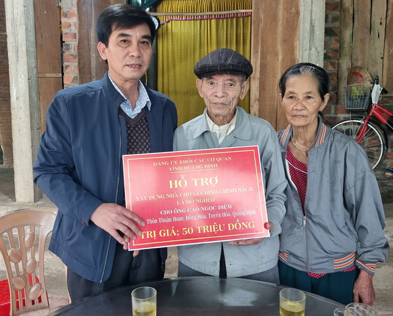 Đồng chí Nguyễn Thanh Lam, Bí thư Đảng ủy Khối các cơ quan tỉnh trao biển tượng trưng cho gia đình đình chính sách xã Đồng Hóa, huyện Tuyên Hóa.