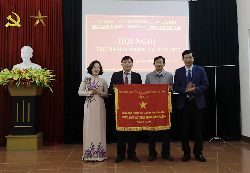 Đồng chí Phó Chủ tịch UBND tỉnh Hồ An Phong trao Cờ thi đua của Chính phủ cho Sở Lao động-Thương binh và Xã hội.