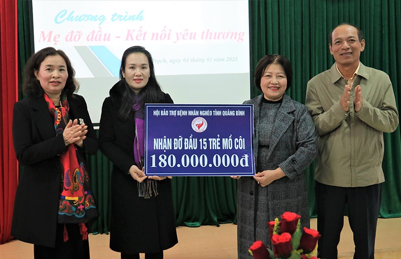 Đại diện lãnh đạo Hội Bảo trợ bệnh nhân nghèo tỉnh cùng đơn vị tài trợ trao biển tượng trưng số tiền hỗ trợ cho đại diện Hội LHPN huyện Bố Trạch.