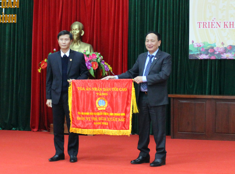 Đồng chí Trần Hải Châu, Phó Bí thư Thường trực Tỉnh ủy, Chủ tịch HĐND tỉnh trao cờ thi đua đua của TAND tối cao cho TAND huyện Bố Trạch