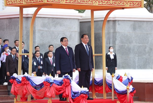 Thủ tướng Phạm Minh Chính và Thủ tướng Lào Sonexay Siphandone nghe quân nhạc cử Quốc thiều hai nước. (Ảnh: Dương Giang/TTXVN)