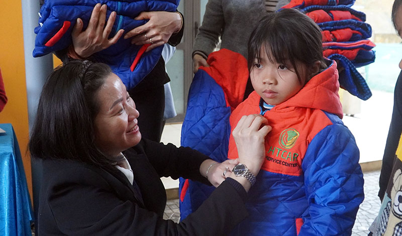 Đại biểu Nguyễn Minh Tâm trao áo ấm cho các em học sinh