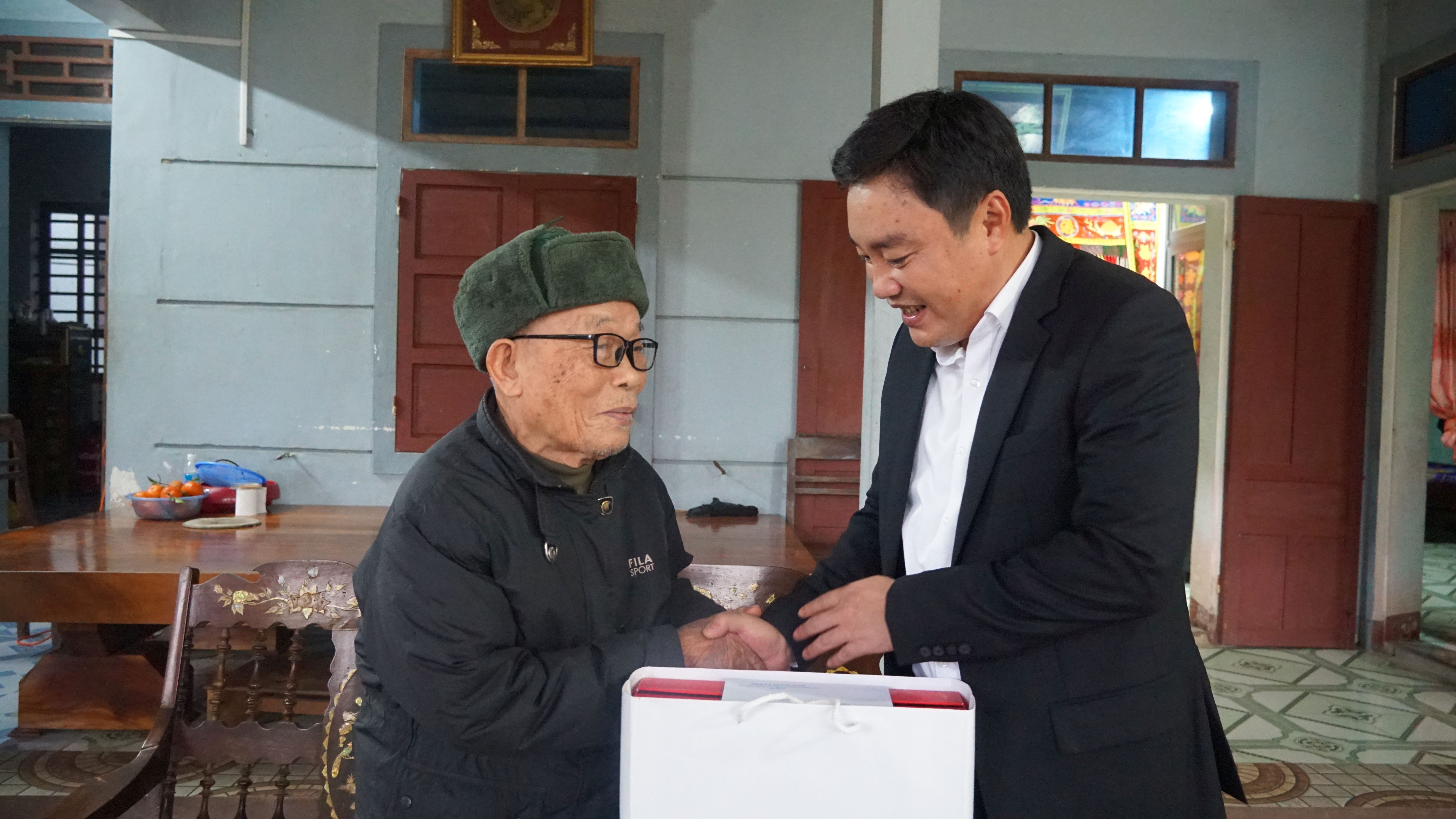 Đồng chí Chủ nhiệm Ủy ban Kiểm tra Tỉnh ủy Đinh Hữu Thành tặng quà đảng viên lão thành Phạm Lập.