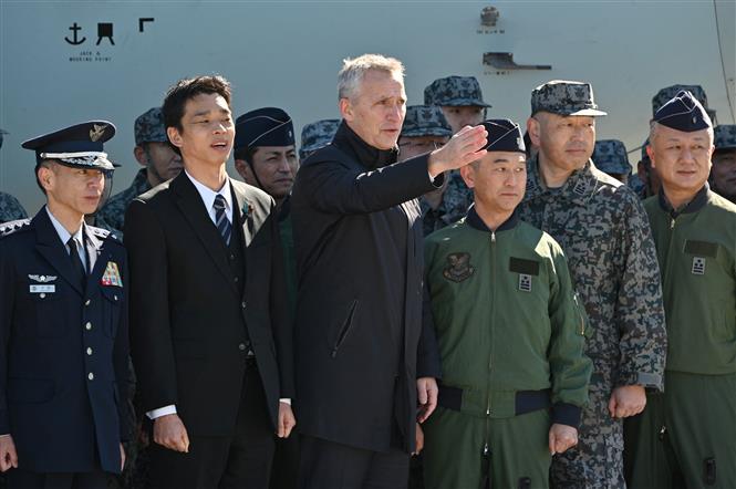Tổng thư ký NATO Jens Stoltenberg (giữa) trong chuyến thăm Căn cứ không quân Iruma, Nhật Bản, ngày 31/1. Ảnh: AFP/ TTXVN