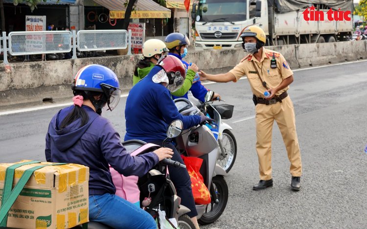 Lực lượng CSGT phát nước suối cho người dân trên đường về quê ăn Tết. Ảnh: Mạnh Linh/Báo Tin tức