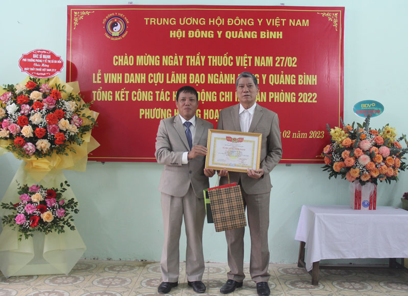 Đại diện lãnh đạo Hội Đông y tỉnh trao bảng vàng vinh danh cho lương y Dương Đình Thân, cựu Chủ tịch Hội Đông y huyện Tuyên Hóa.