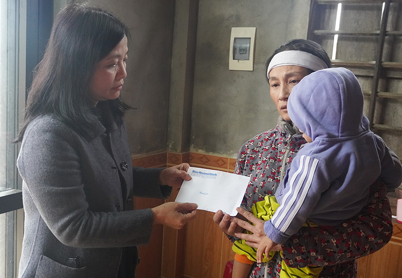Đại diện lãnh đạo Báo Quảng Bình trao tiền hỗ trợ cho đại diện gia đình em Nguyễn Văn Thống.