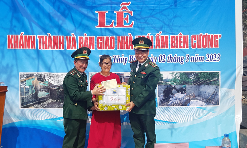 Đại tá Trịnh Thanh Bình, Chỉ huy trưởng và thượng tá Ngô Minh Điền, Phó Chính ủy BĐBP Quảng Bình trao quà cho bà Võ Thị Đa nhân dịp bàn giao ngôi nhà  