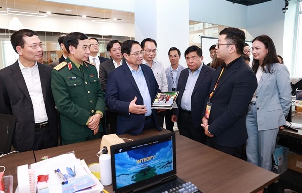 Thủ tướng Phạm Minh Chính trò chuyện với các cán bộ, nhân viên trong các đơn vị nghiên cứu, sản xuất của Trung tâm Đổi mới sáng tạo Quốc gia (NIC). (Ảnh: Dương Giang/TTXVN)